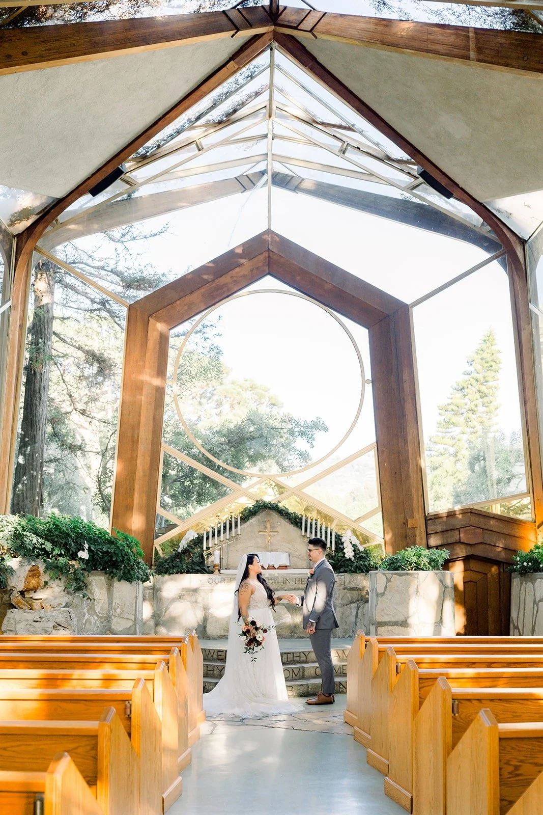 Betsy and Mikey at the end of the empty aisle of Wayfarers Chapel