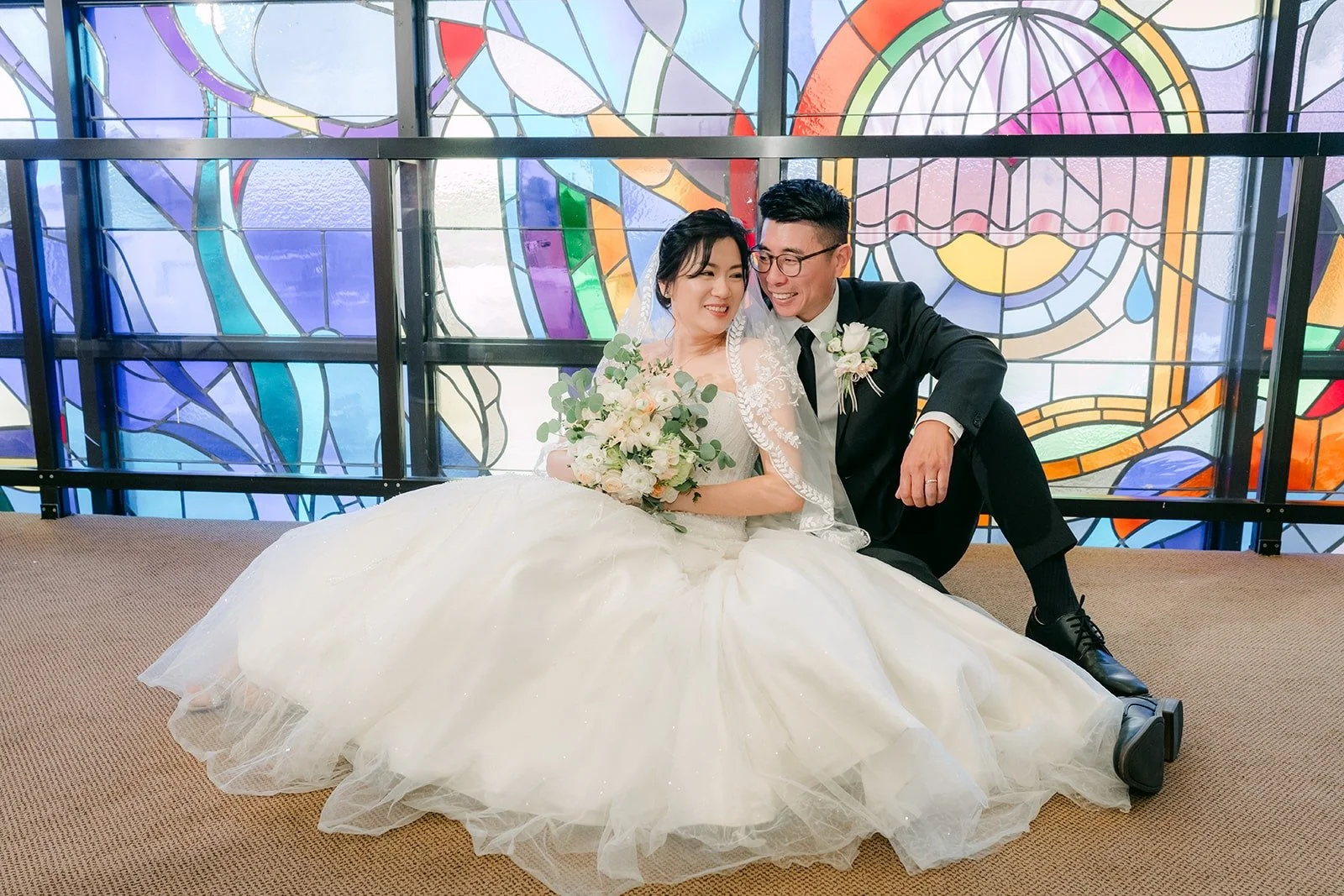 Eunice and Eric sit together in front of the Rainbow Glass Wall at Mandarin Baptist Church of Los Angeles