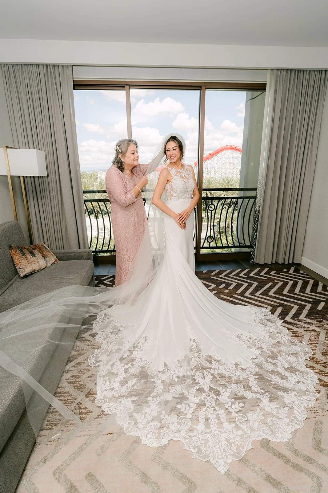 A bridesmaid helps Francesca with her gown as the lace train spreads across the floor