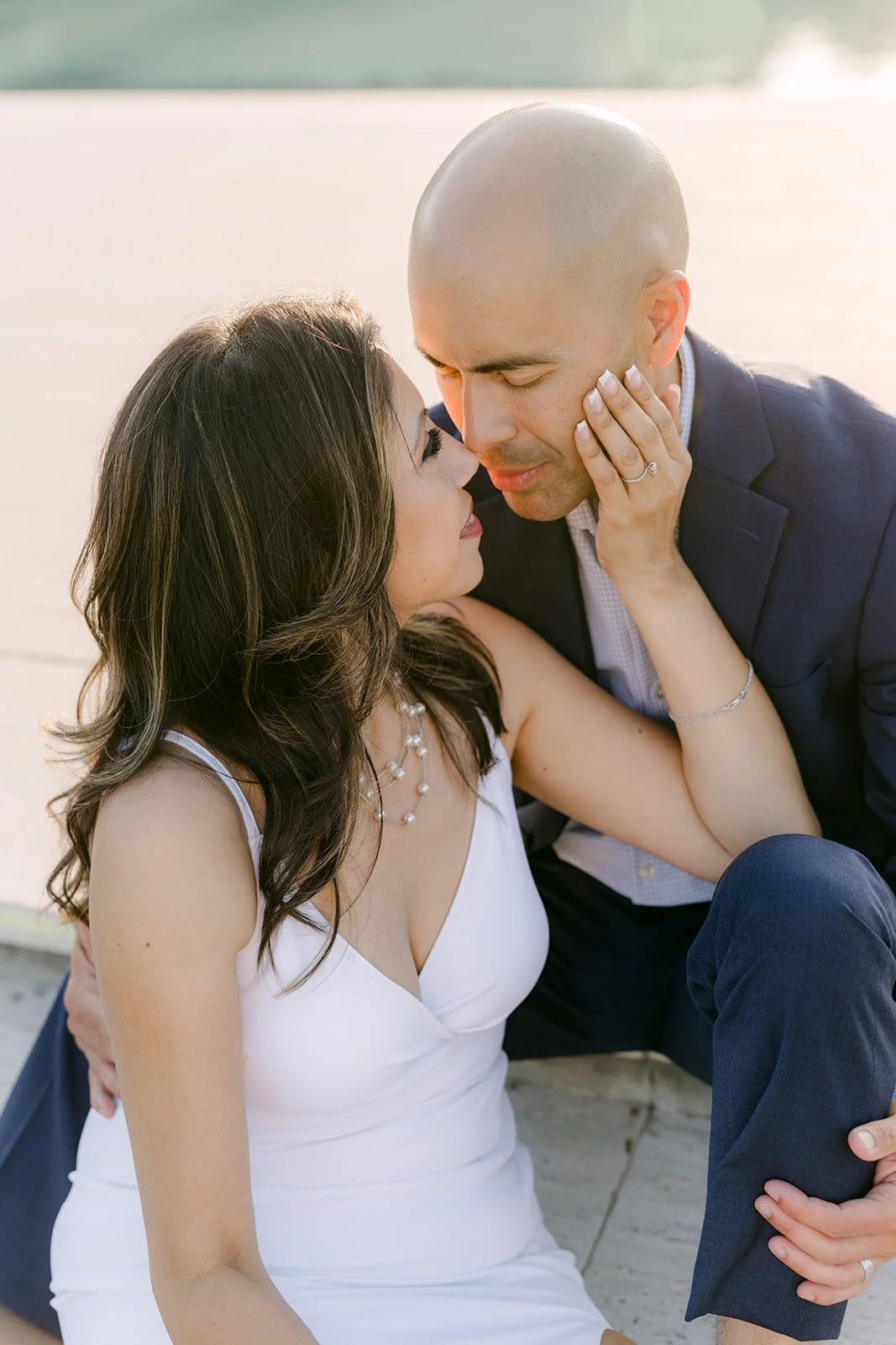 Daniel leans in to kiss Francesca's forehead at golden hour.