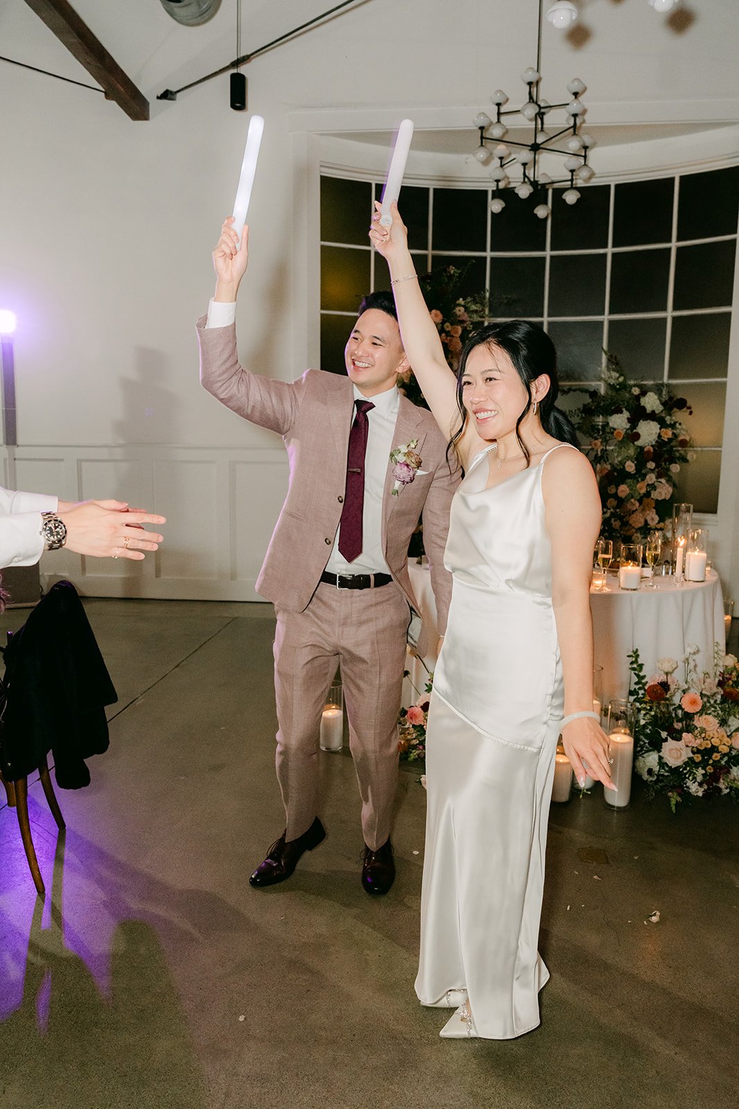 Denise and Michael on the dance floor with light-up foam sticks, photographed by One and Only Production.