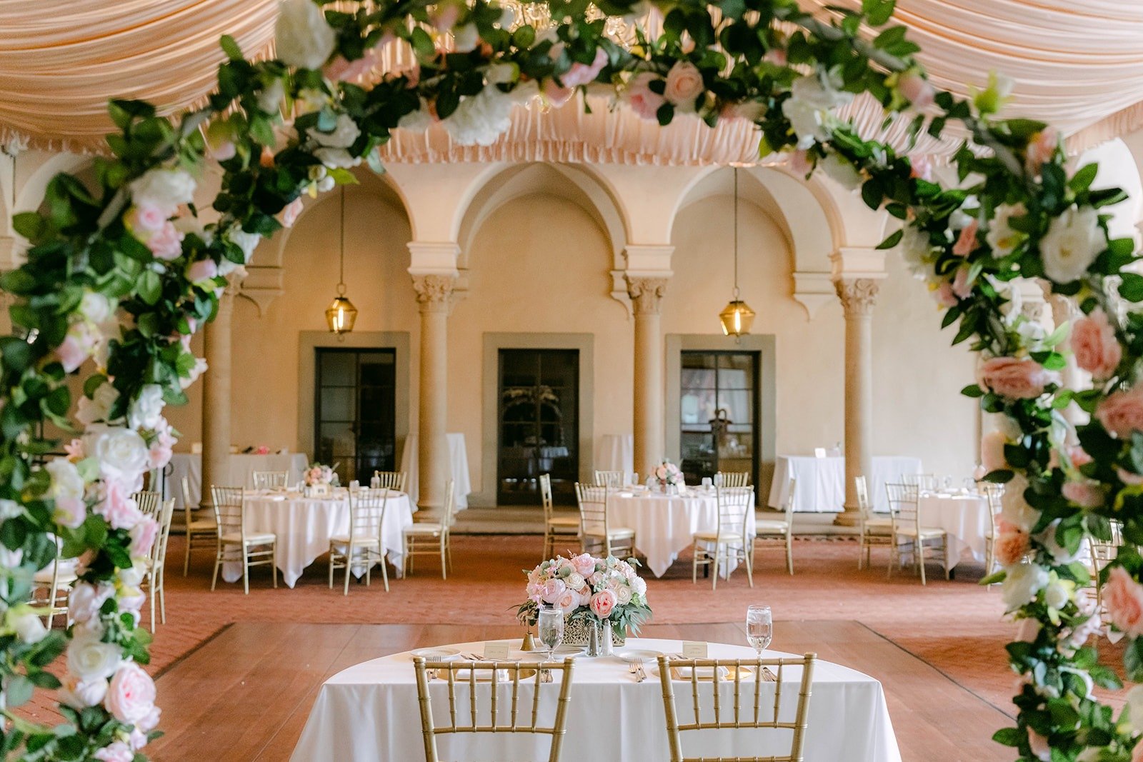 A view of the reception tables through the rose arch