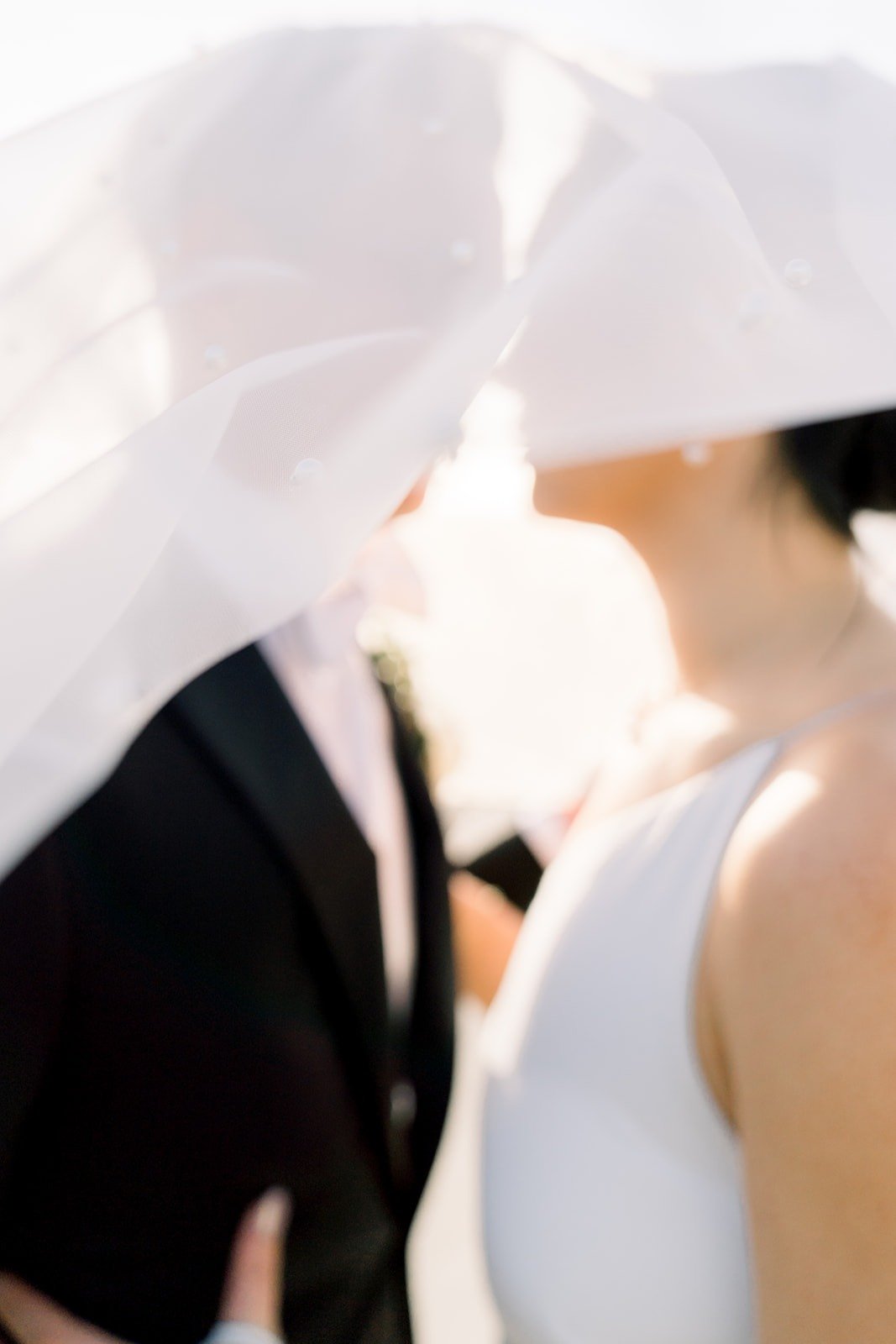 Cindy's veil catches the wind as Alex leans in
