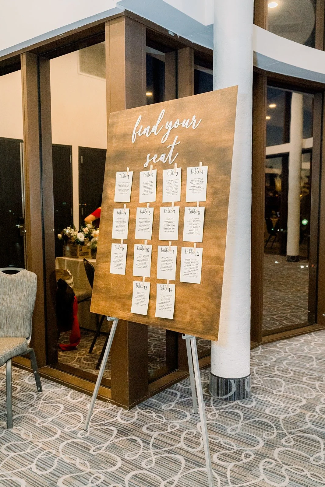 A wooden seating chart with clipped table cards
