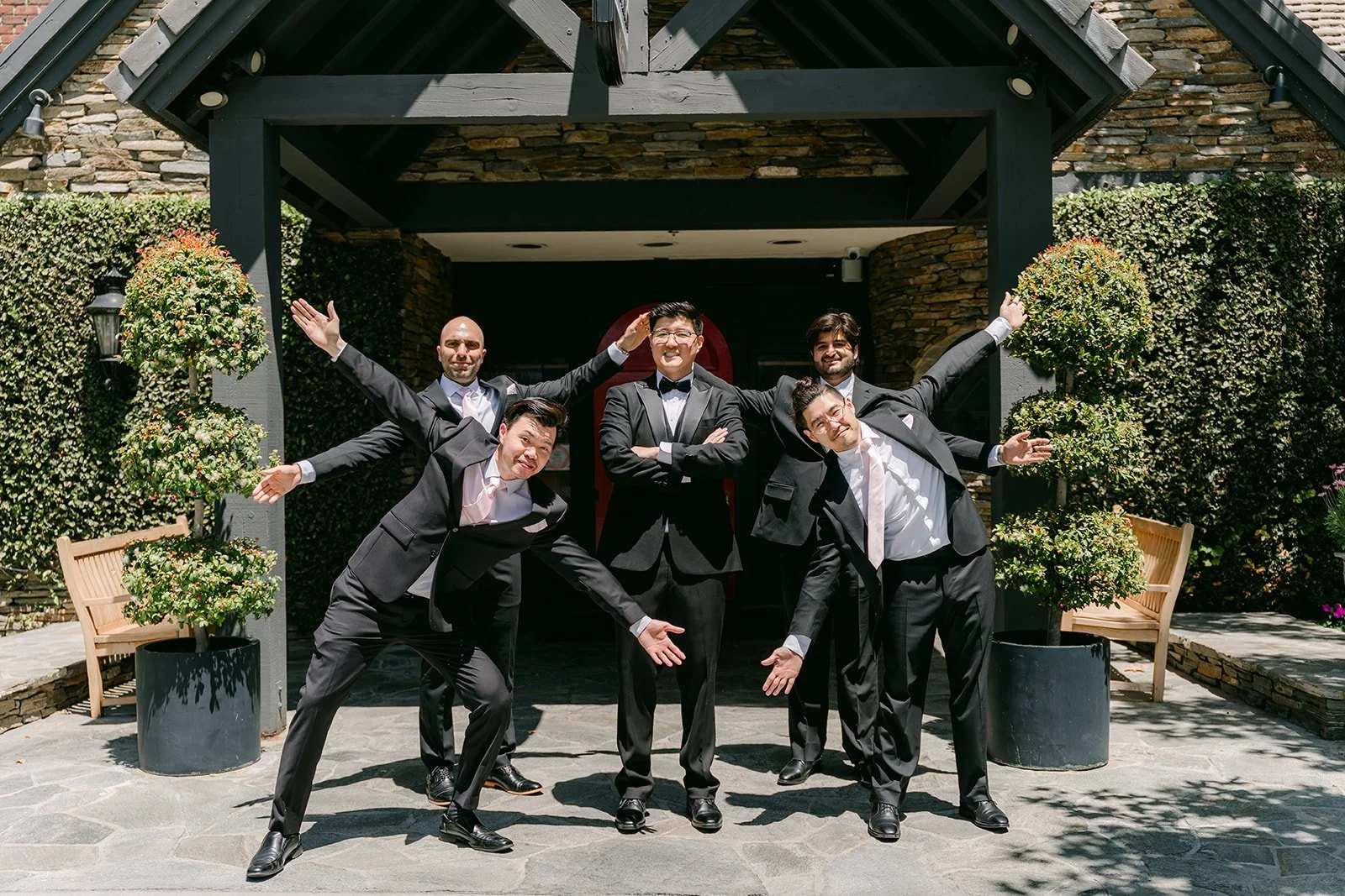 The groomsmen goofing around on the lawn