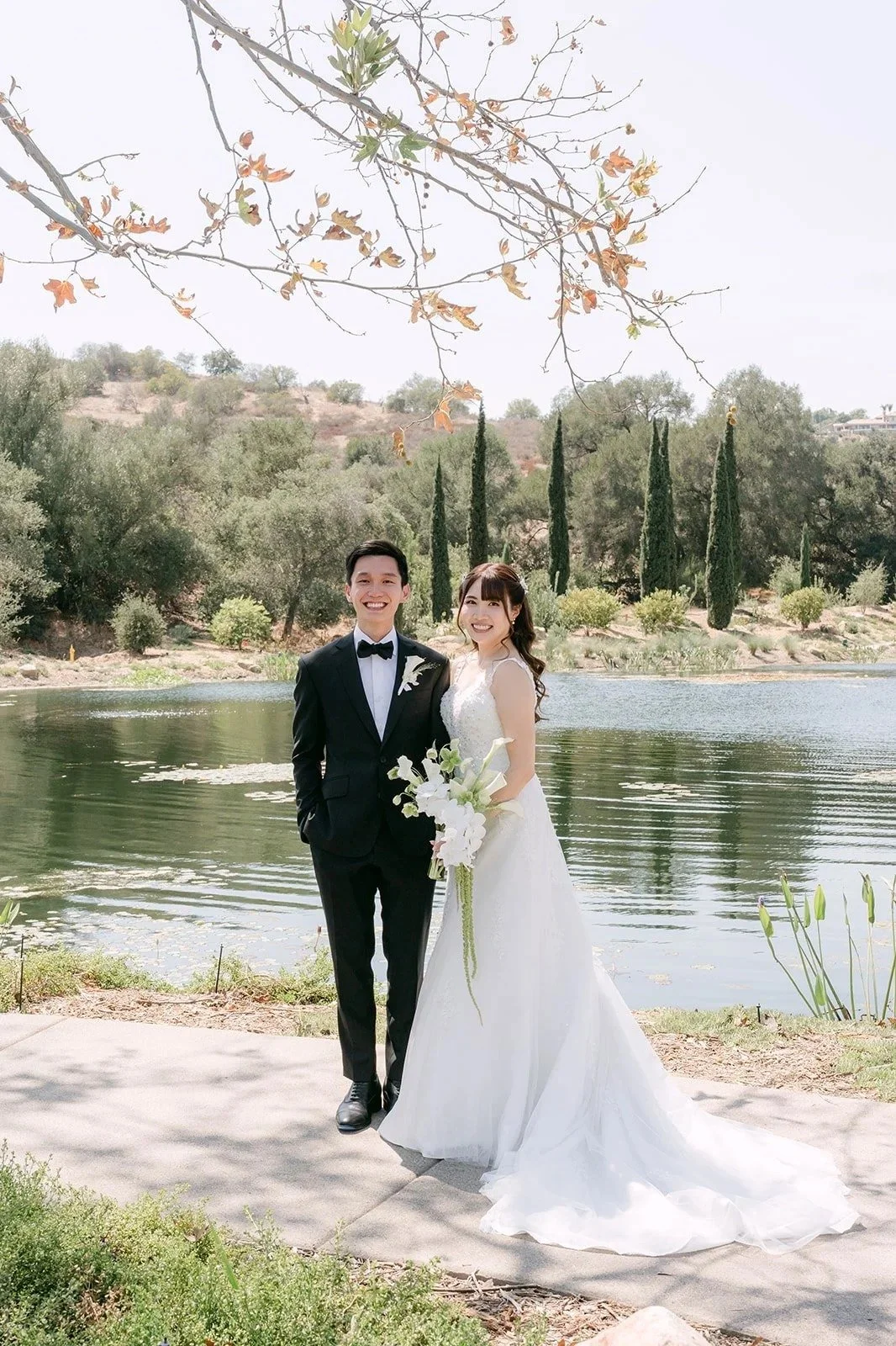Couple portrait on the lakeside path under autumn branches