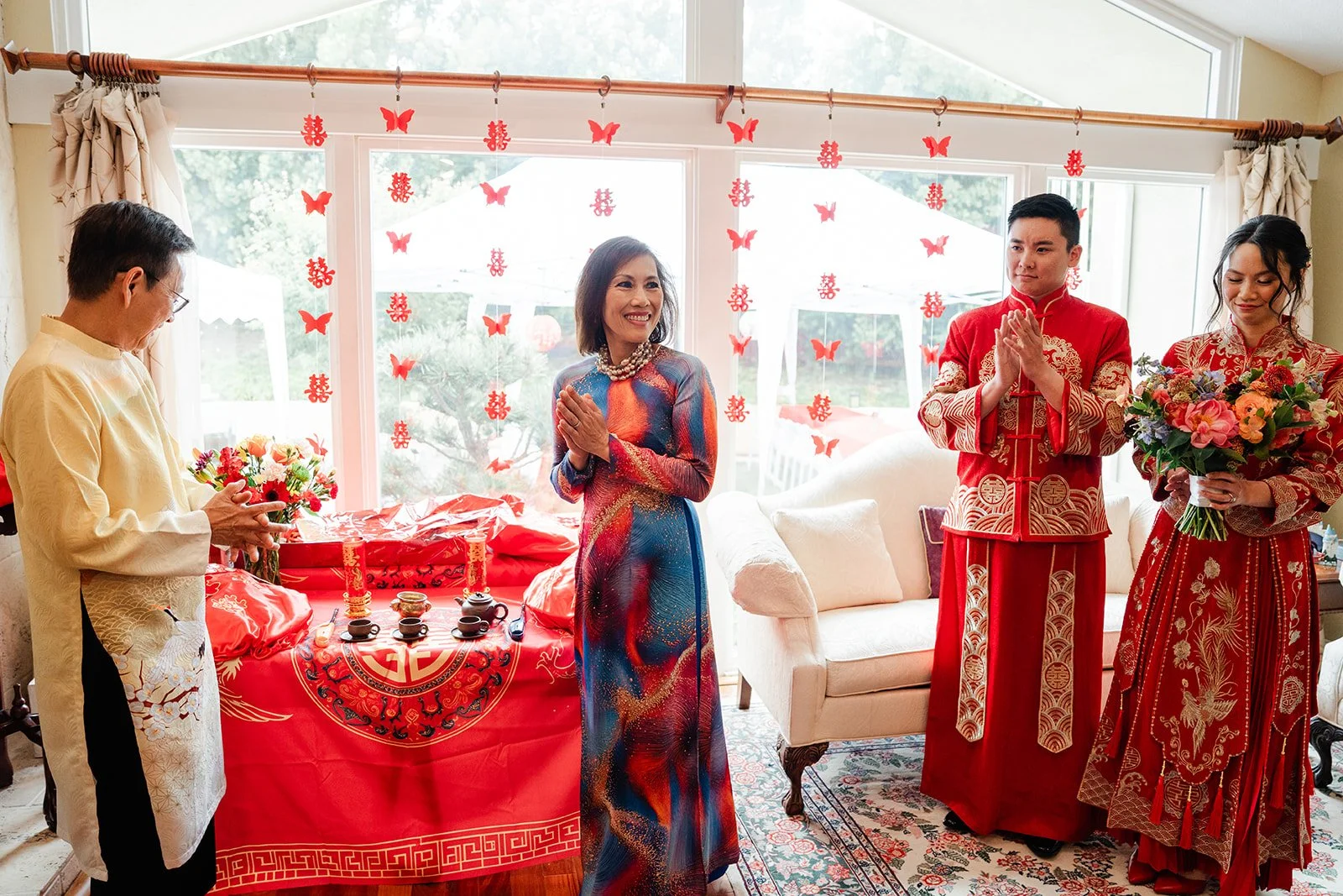 Bridgette and Henrik serving tea in front of the double happiness backdrop.