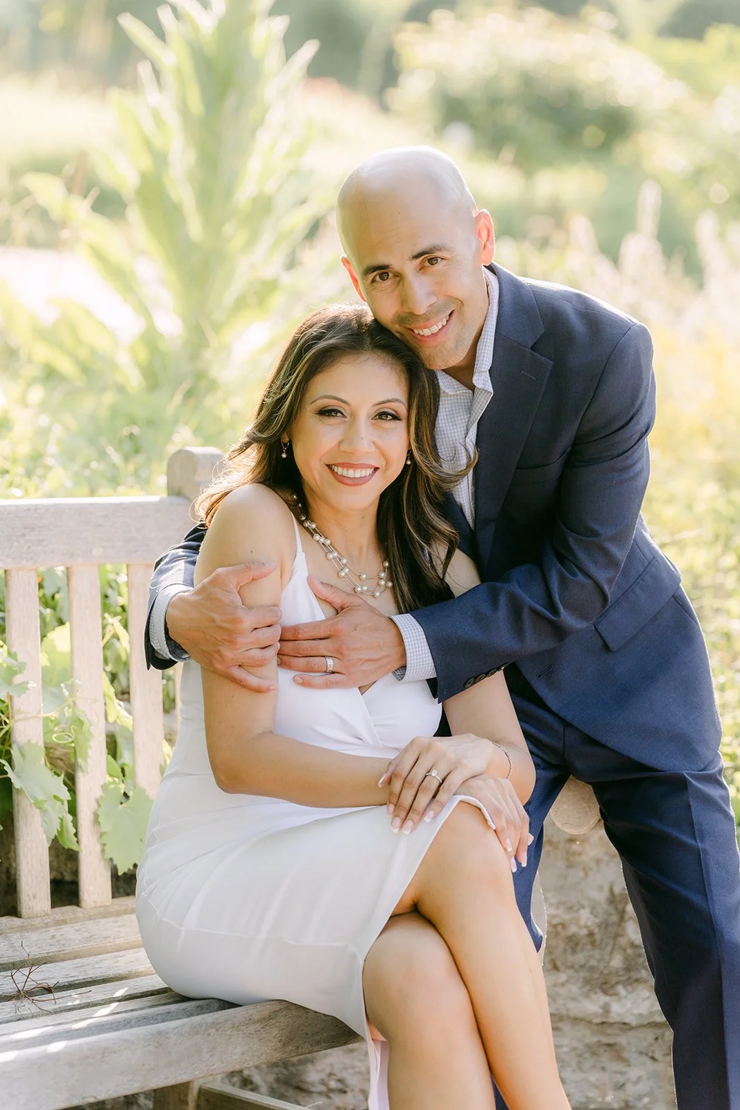 Daniel wraps his arms around Francesca as she sits on the bench.