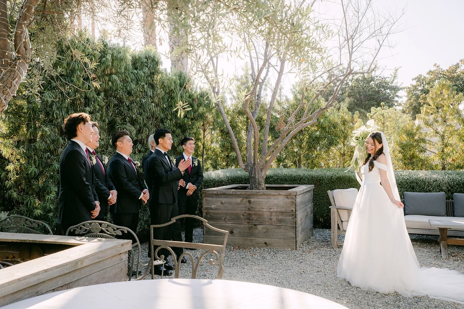 The groomsmen watching the first look from across the garden, photographed by One and Only Production