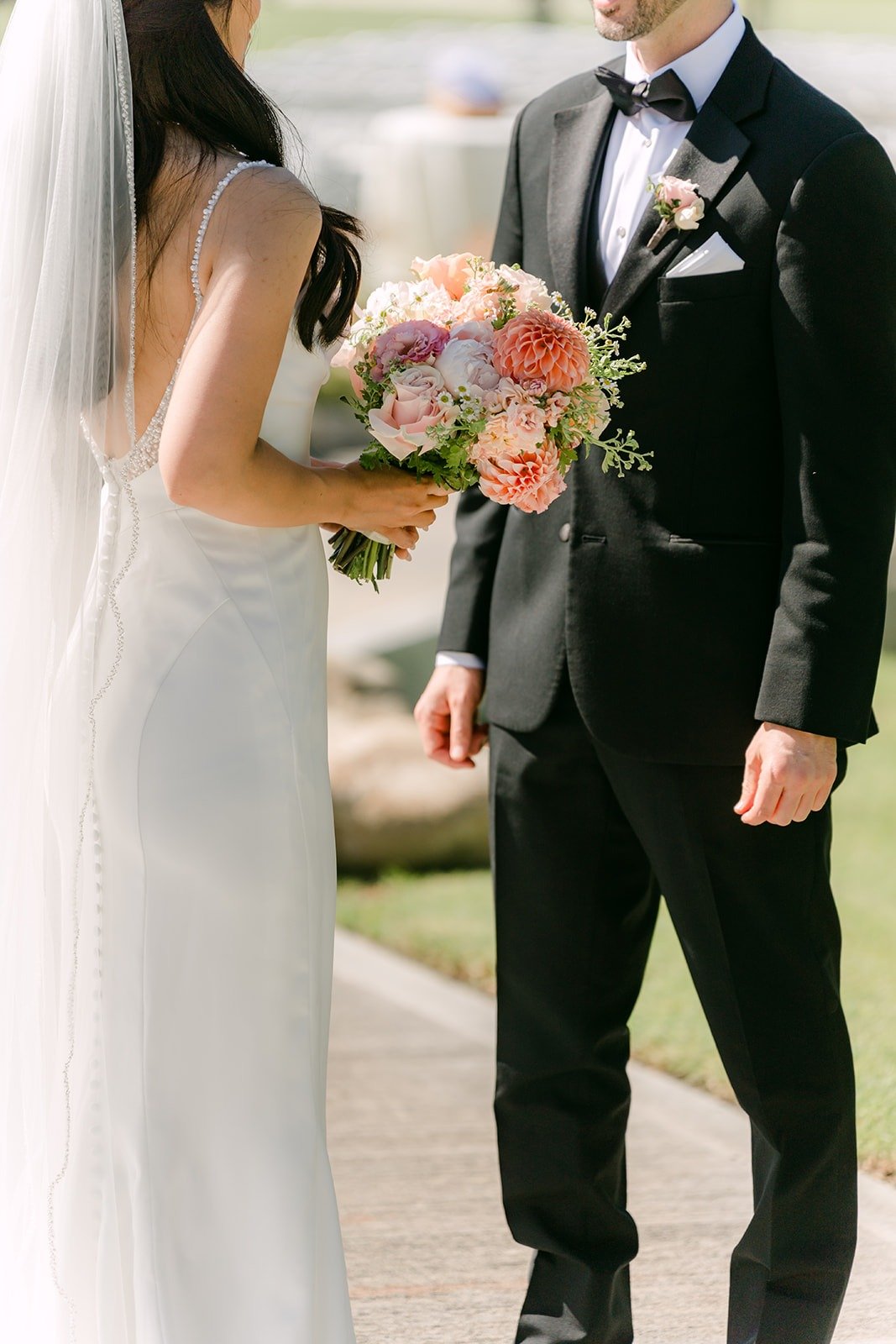 Kevin holding Stephanie's hand as they face each other during their first look