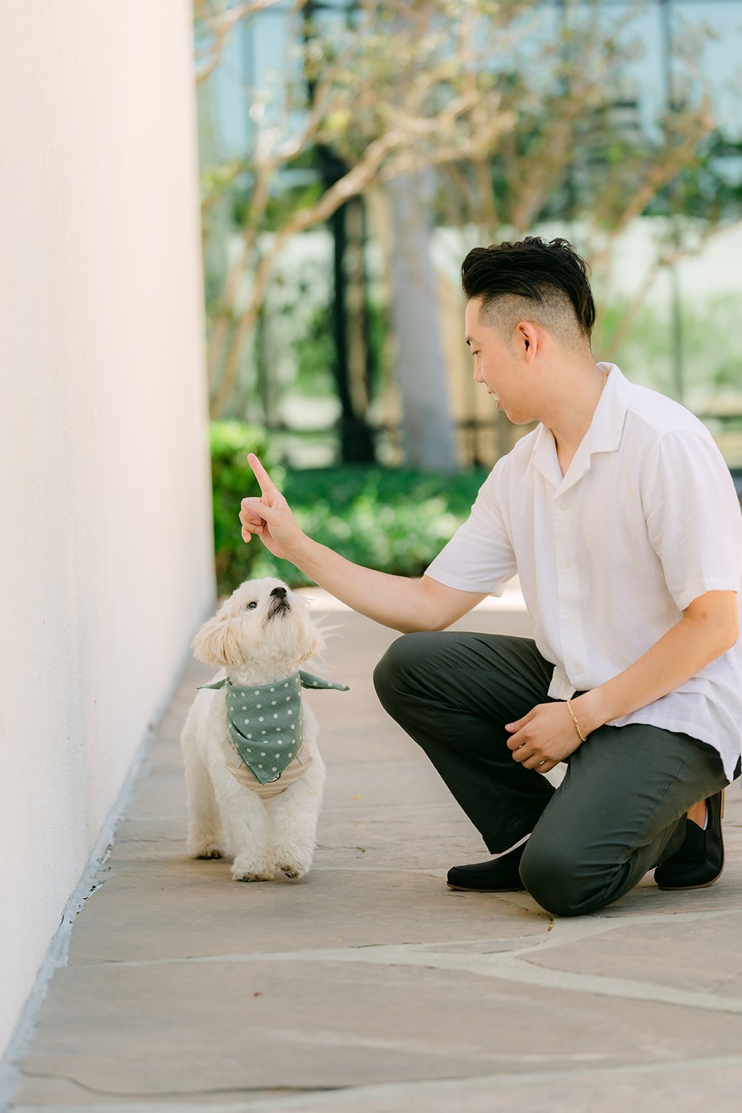 Alan crouches beside Tofu along the white wall.