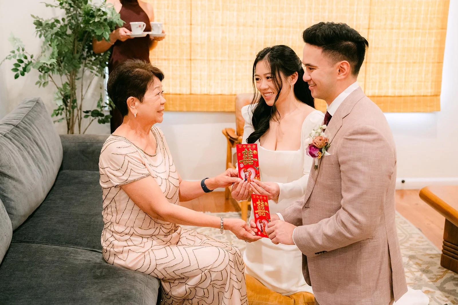 Denise's mom giving the couple a gift during the tea ceremony.