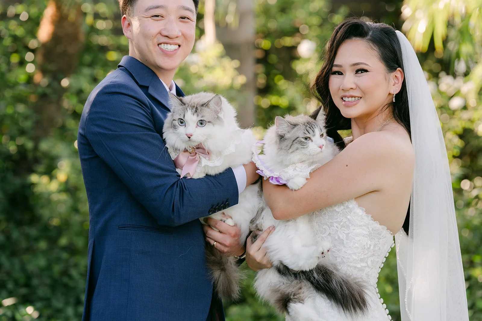 Vannie and Elijah holding their two fluffy cats.