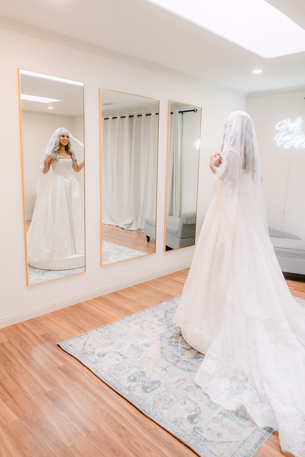 Konitha in her gown and lace veil in the Bel Vino bridal suite mirrors