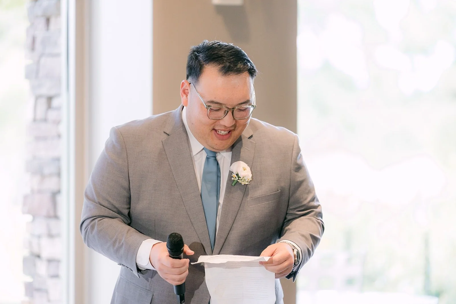 A groomsman giving a speech with notes in hand