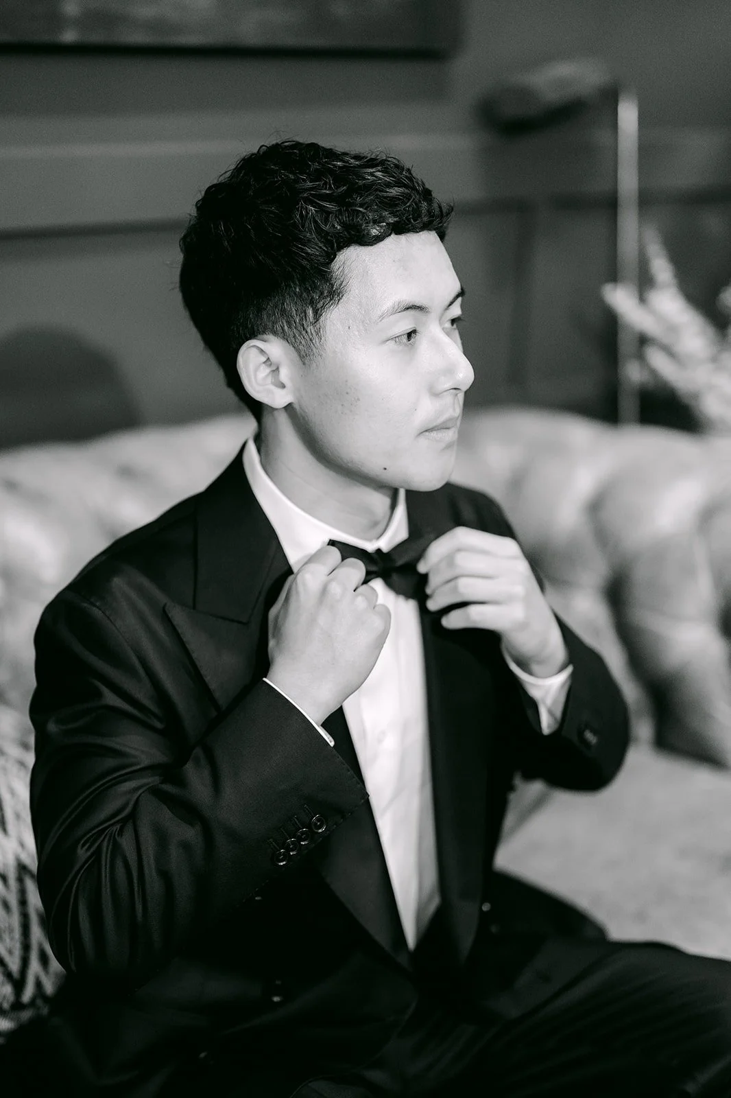 Black and white photo of Richard adjusting his bow tie