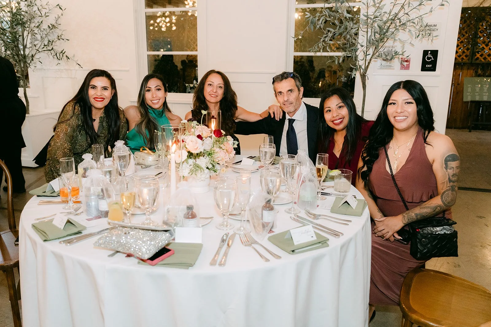 A table of friends smiling at the reception.