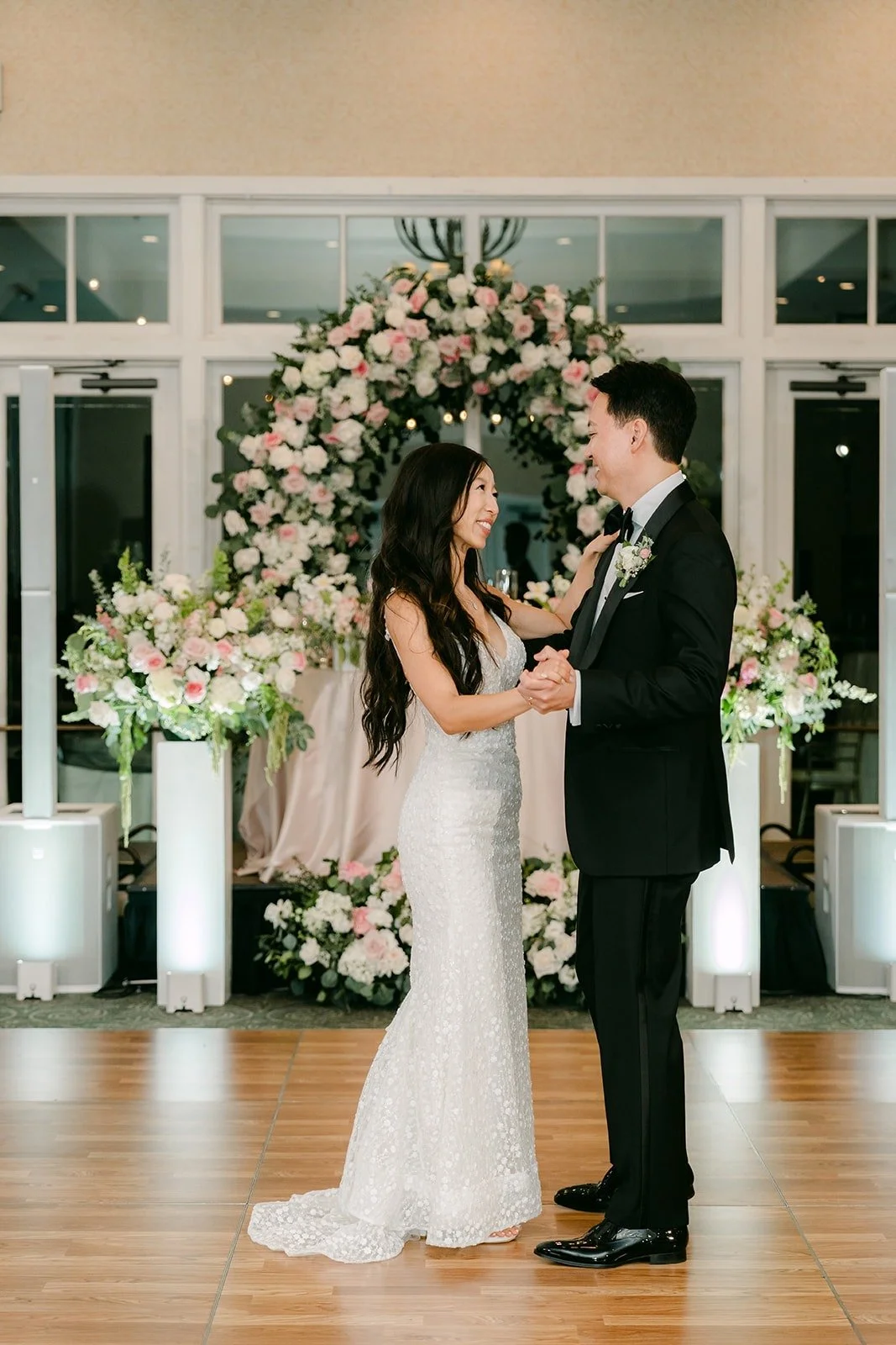 Kristine and William dancing in front of the floral arch