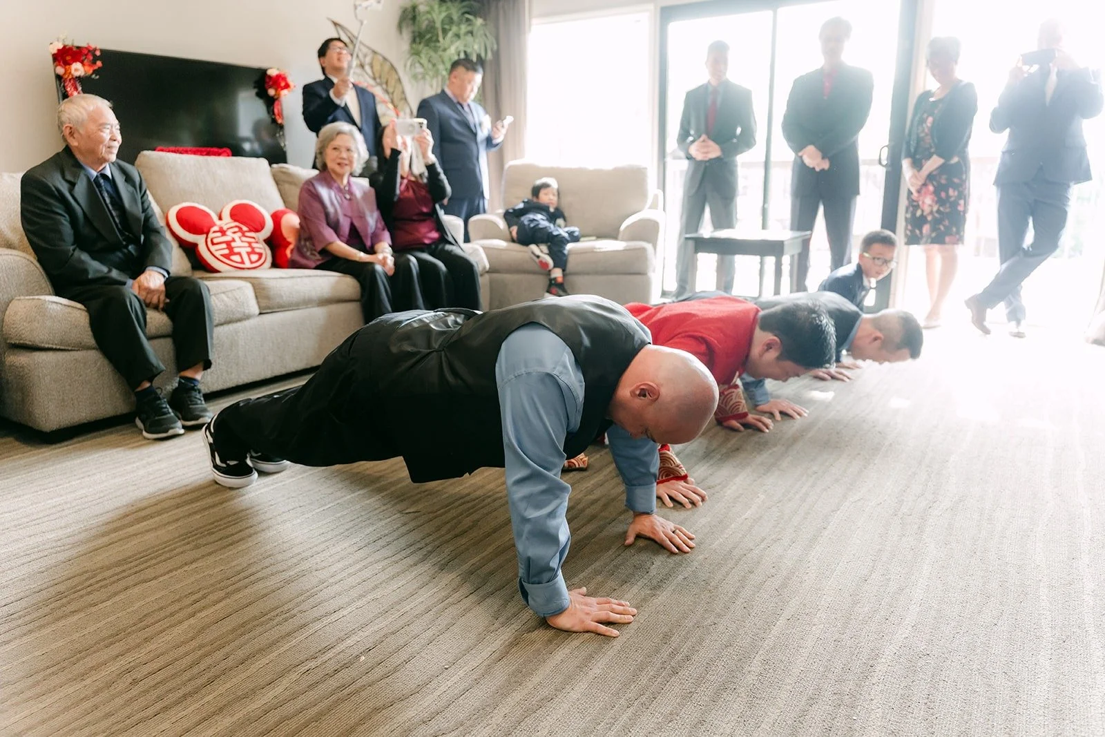 Groomsmen do push ups on the hotel room floor as one of the door game challenges