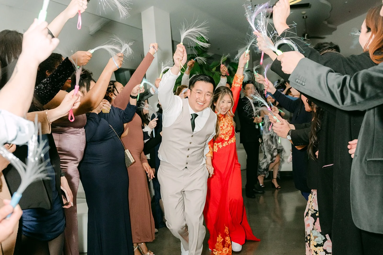 Guests waving ribbon wands around the couple