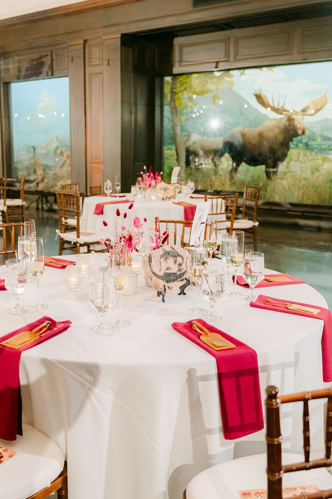 Tables with crimson napkins beside the moose diorama