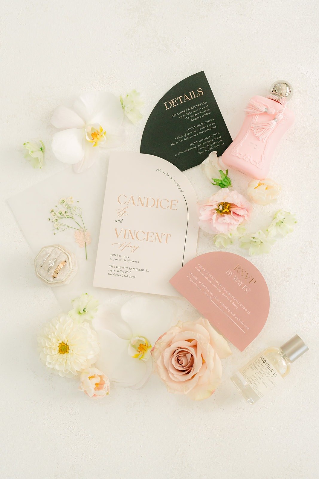 Candice and Vincent's invitation suite with a black details card, perfume and blush roses