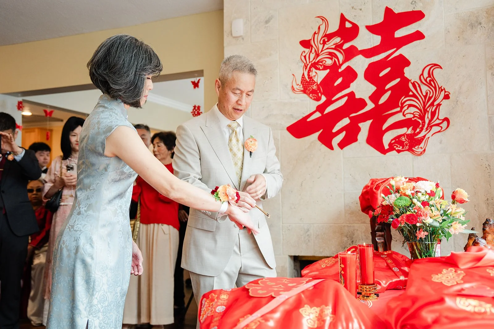 An elder in front of the double happiness papercut during the tea ceremony.