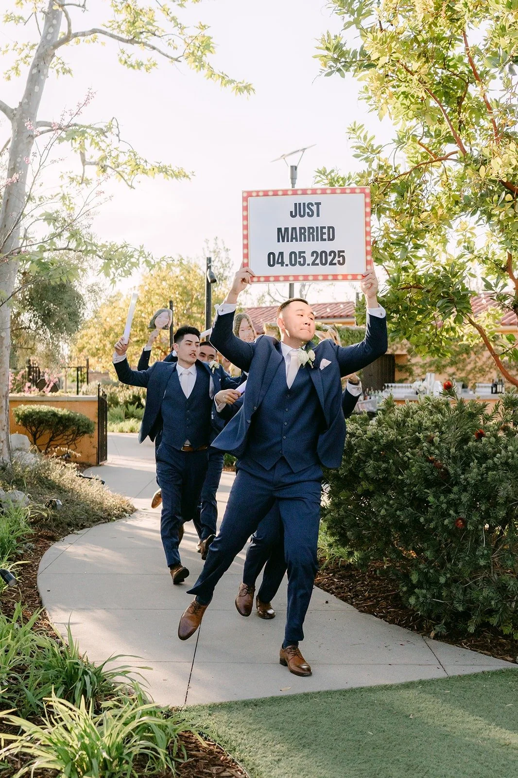 Groomsmen making their grand entrance with a sign at Los Robles Greens
