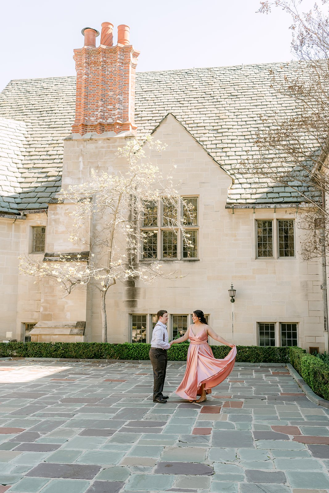 Matthew twirls Saira in the courtyard beneath the mansion's brick chimney.