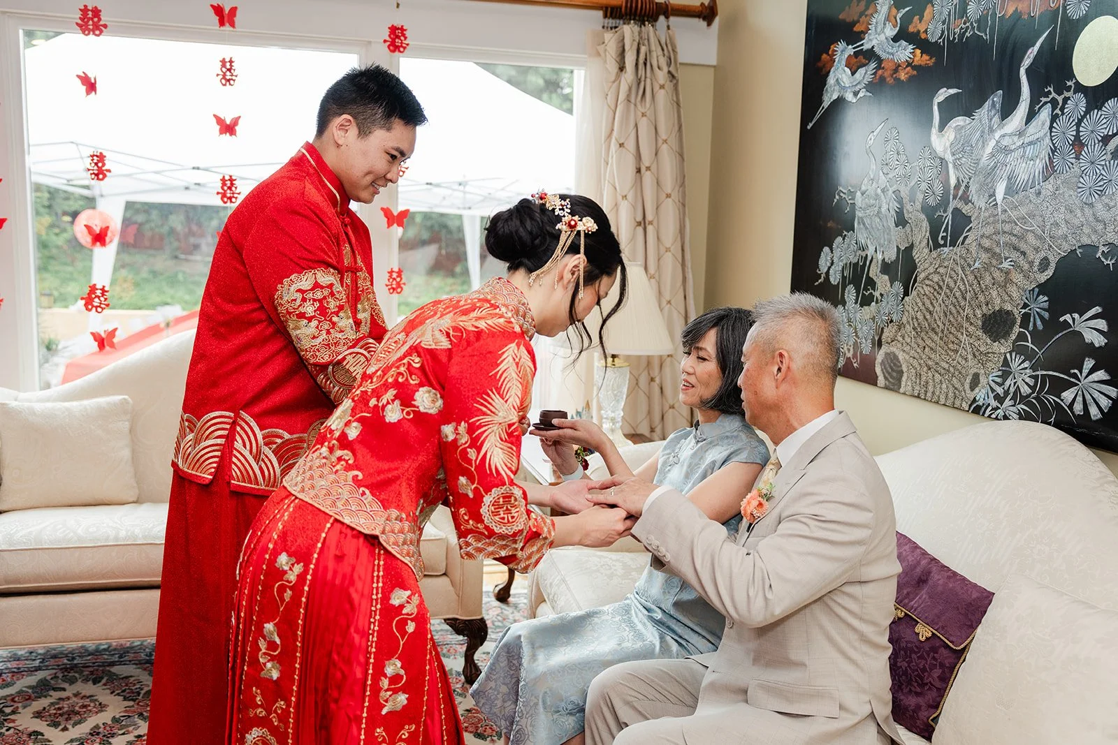 The couple bowing to a grandparent during the tea ceremony.