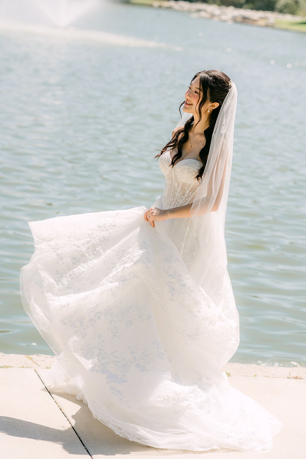 Clarissa twirling her gown on the lakeside path