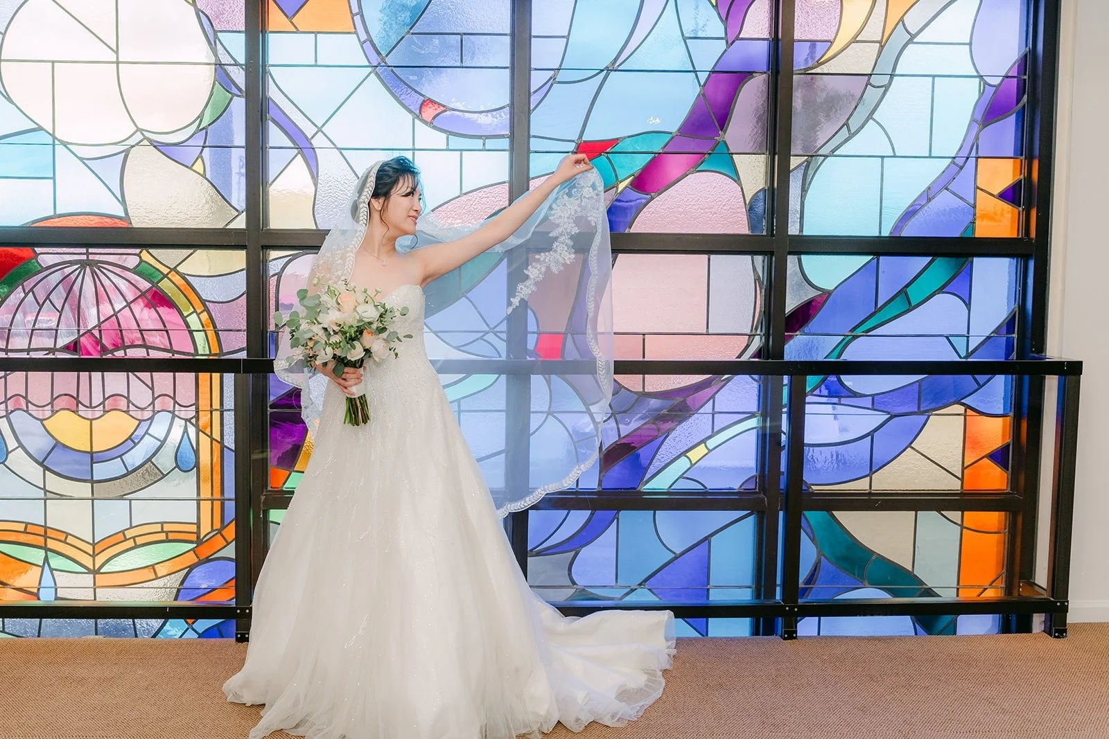 Eunice tosses her veil in front of the Rainbow Glass Wall