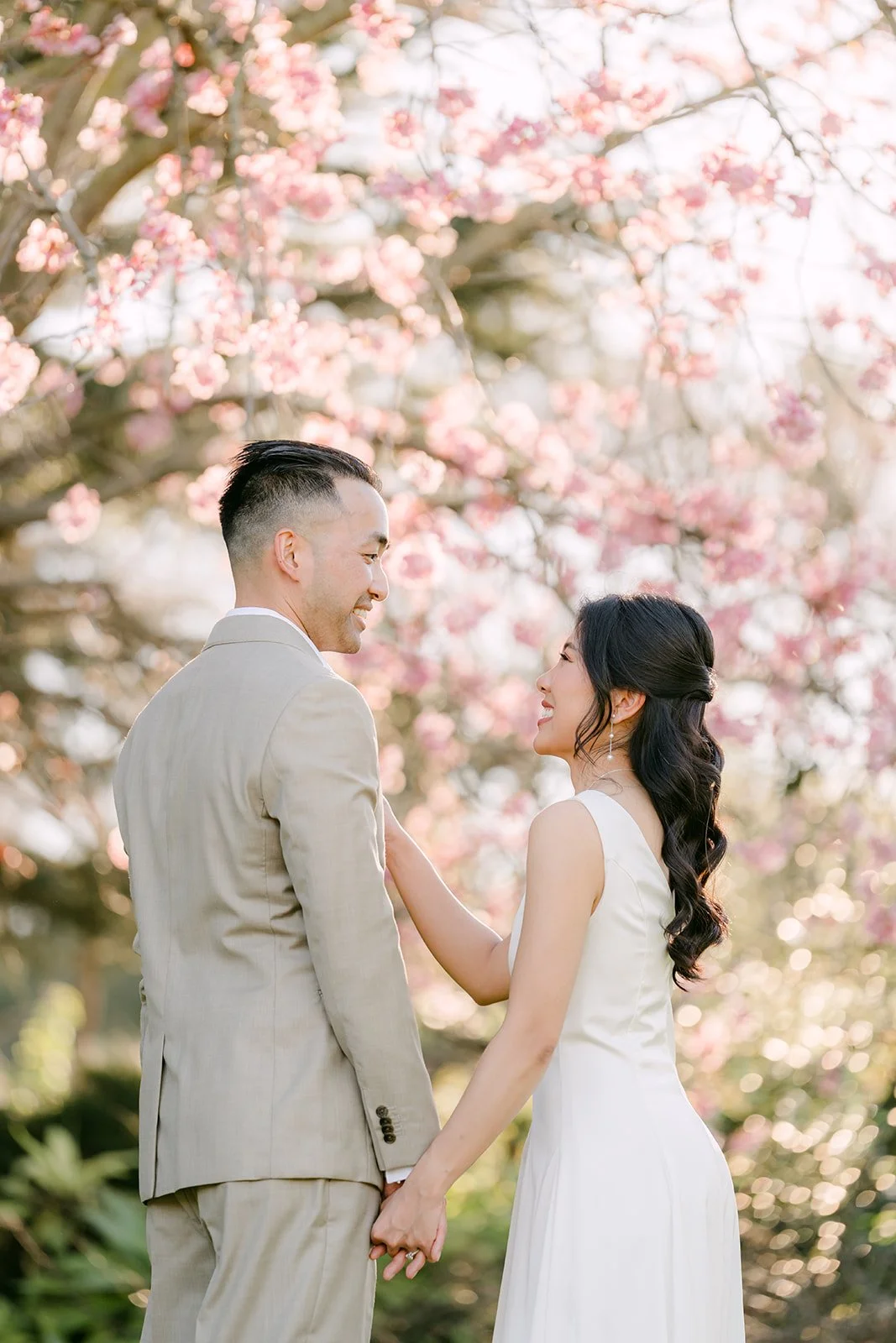 Kim and Vincent facing each other under a blossoming tree.