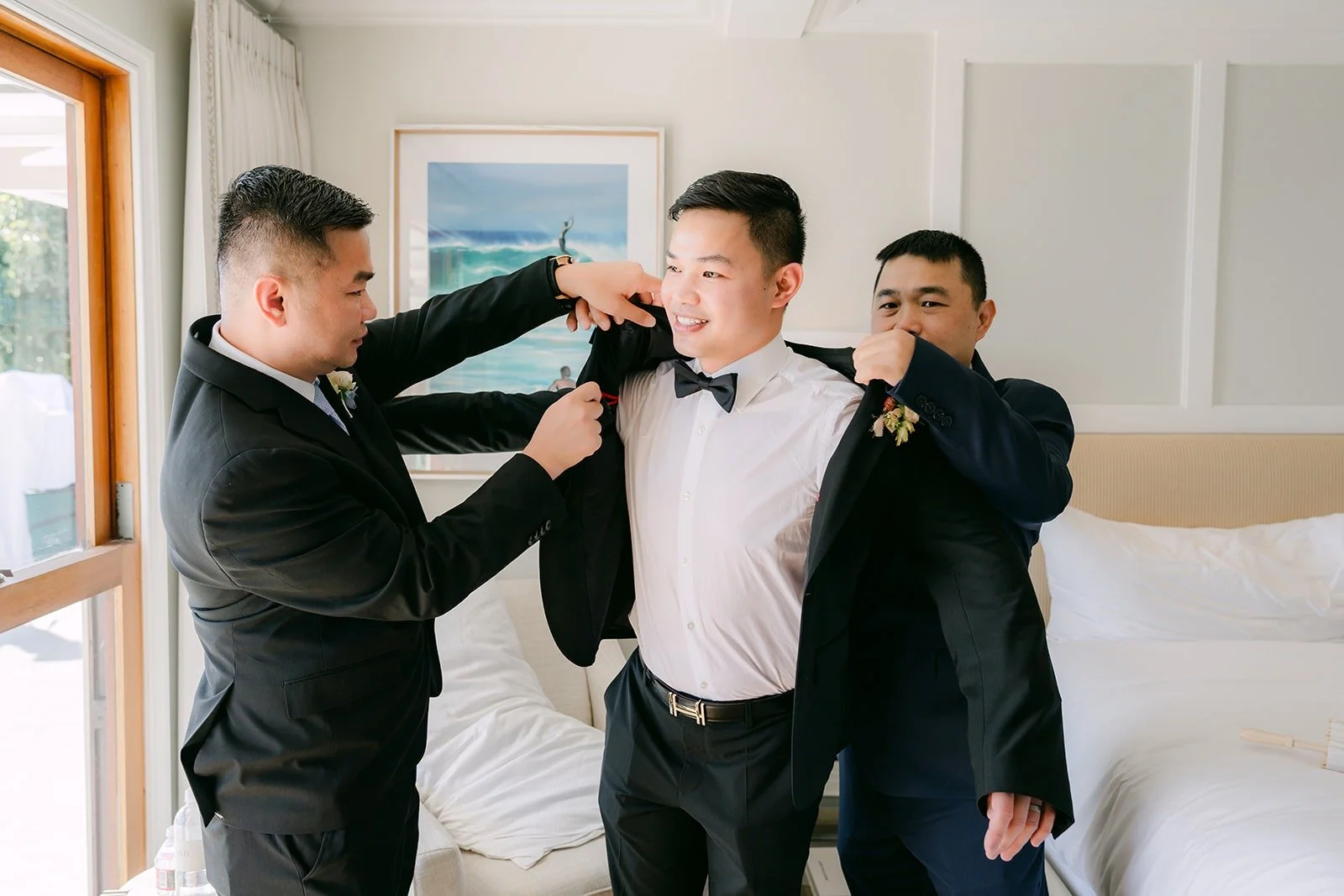 Two friends helping Mario with his jacket and boutonniere