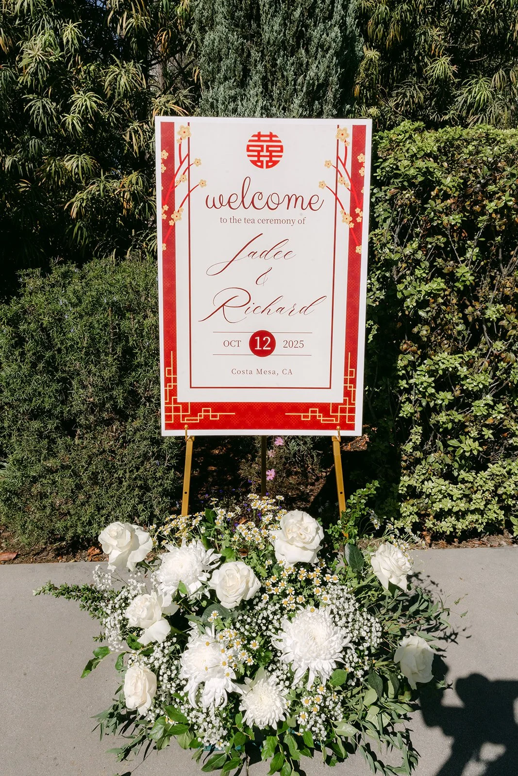 Red tea ceremony welcome sign with white flowers in the garden