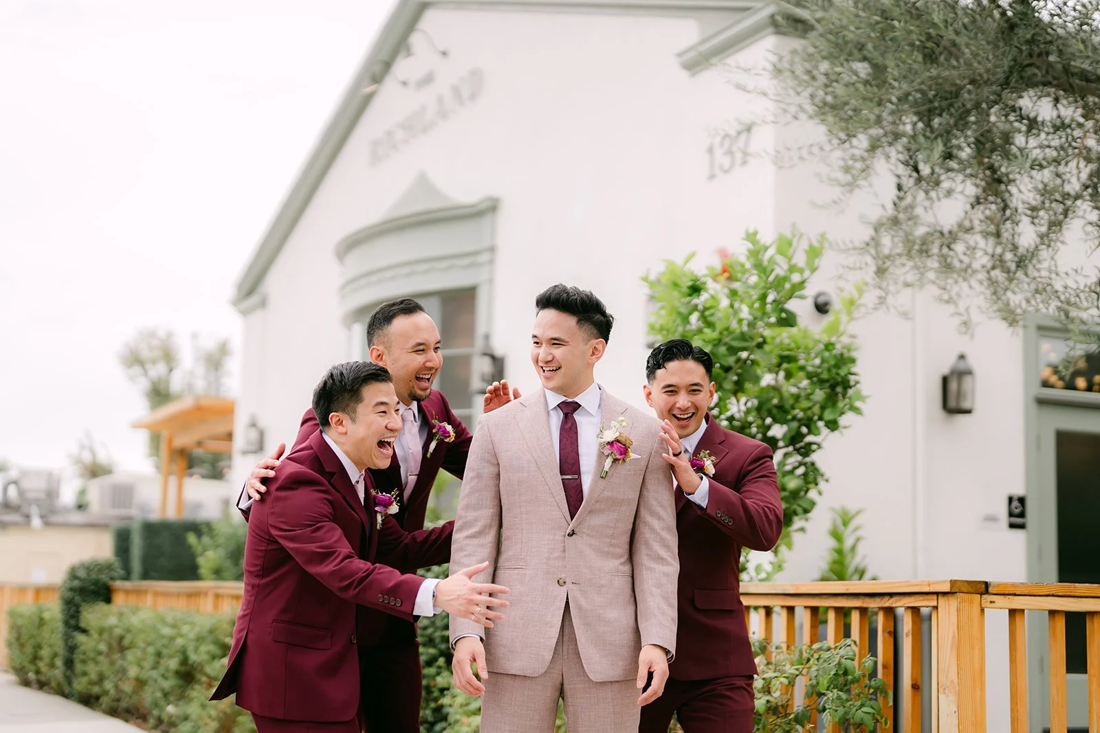 Michael laughing with his groomsmen outside The Richland, photographed by One and Only Production.
