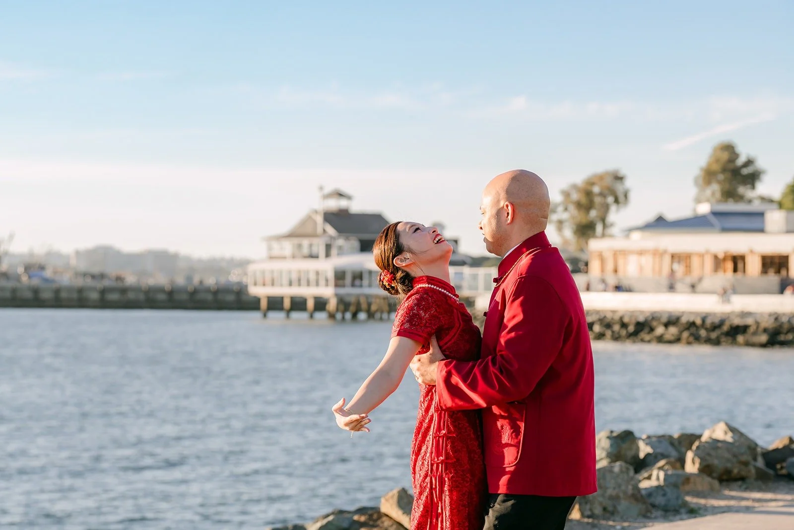 Elisa and Brandon walk along the waterfront path with Seaport Village behind them