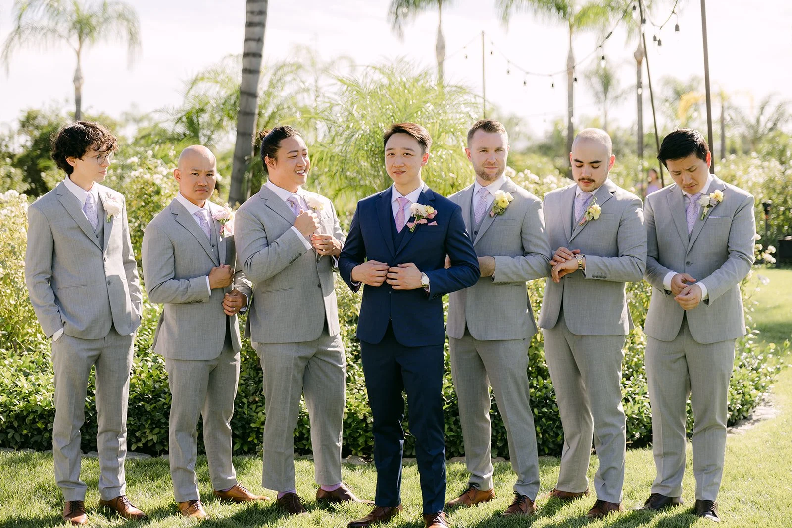 Elijah and his groomsmen in gray suits under the palms.