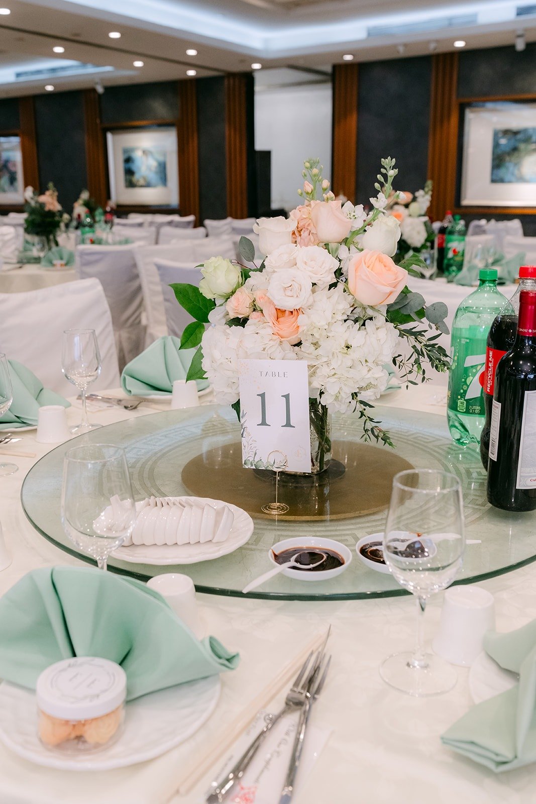 A round table set with sage green napkins and a lazy Susan