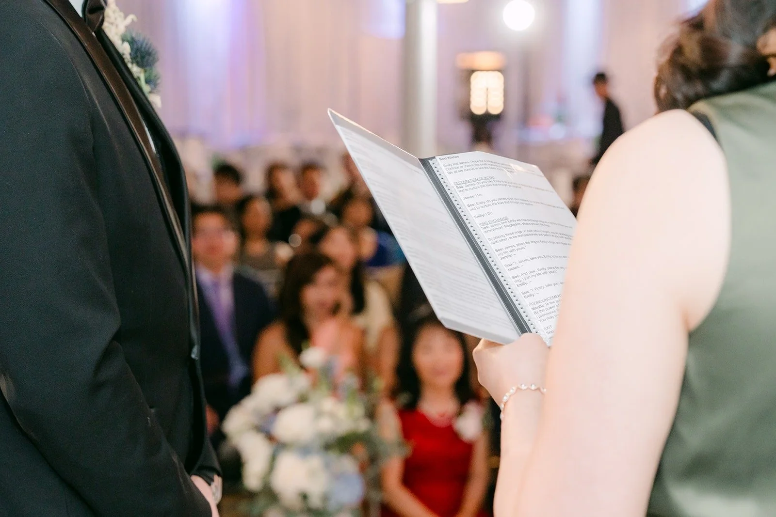 Officiant reading from her book as guests watch