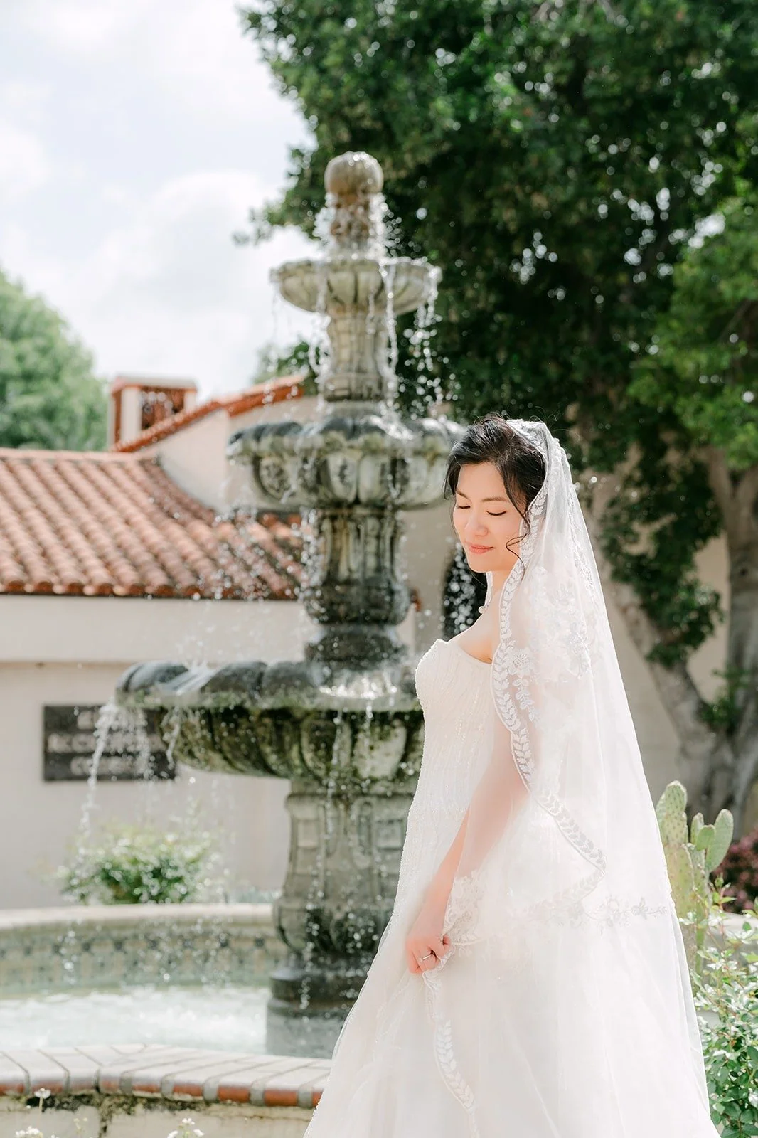 Eunice in her long veil beside the tiered fountain