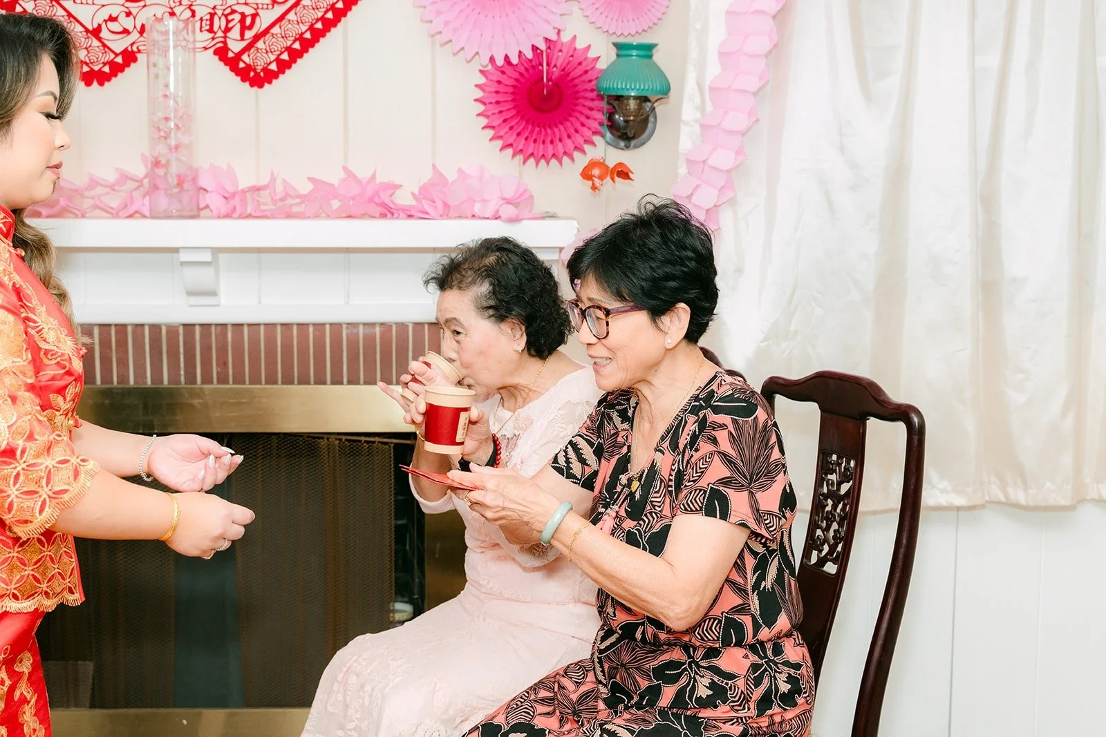 An elder receiving tea from Candice and Vincent