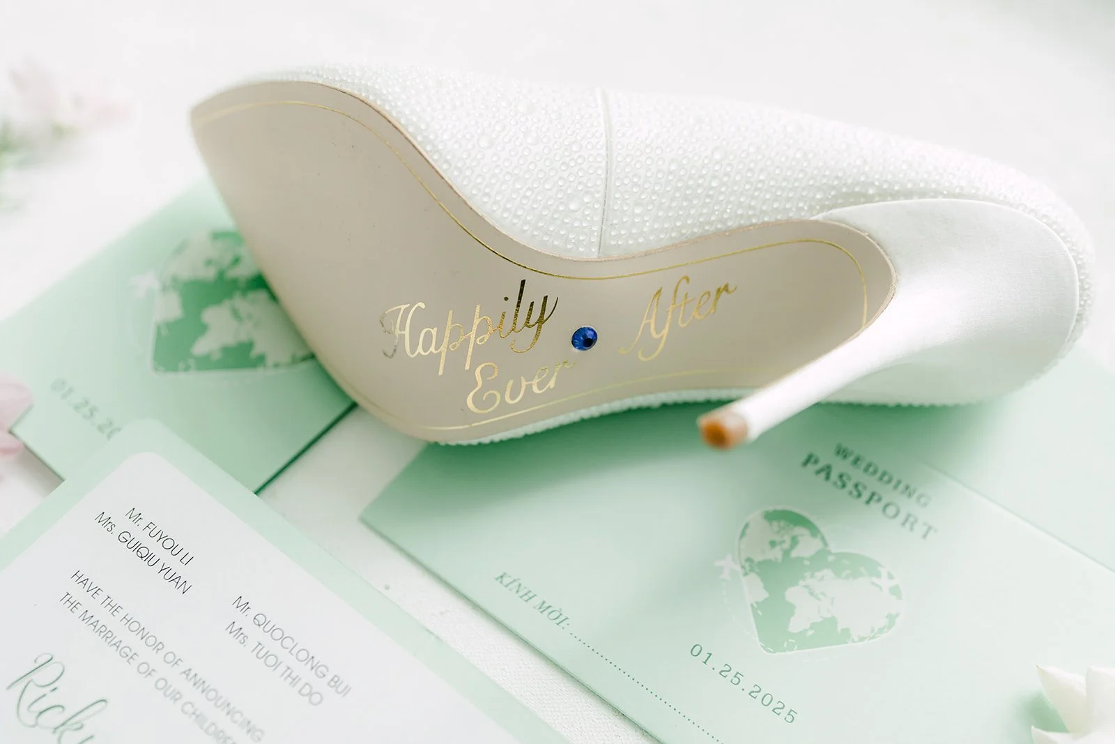 White bridal heel with a written message on the sole resting on mint stationery