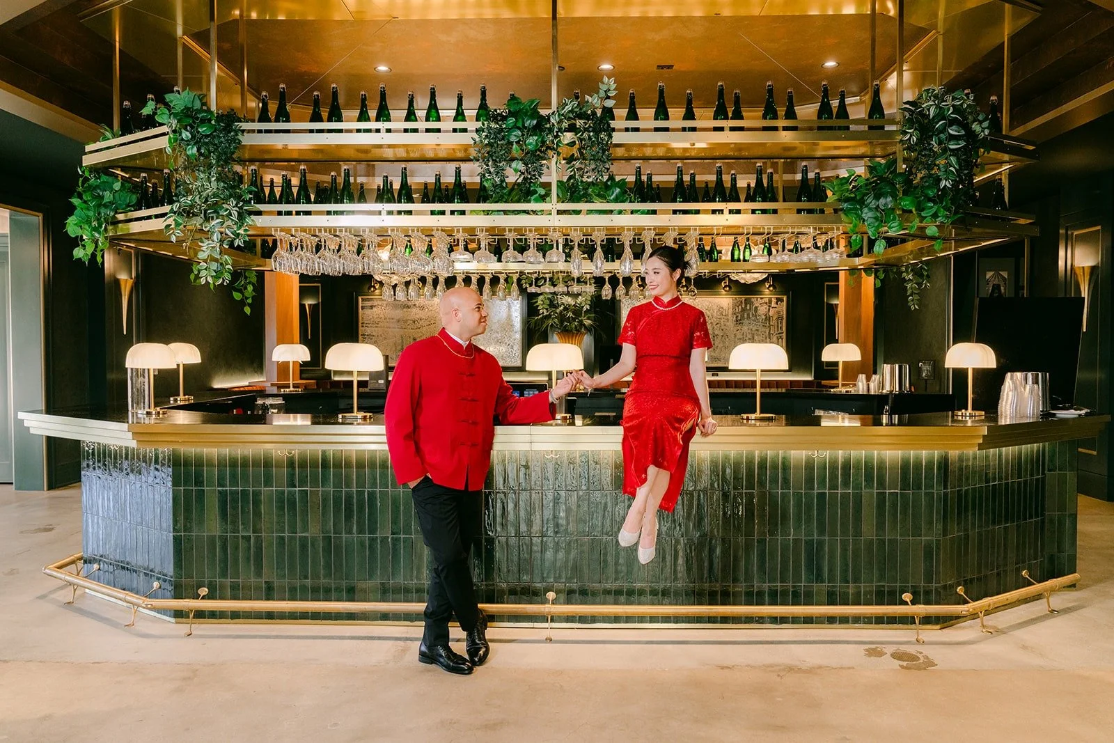 Elisa and Brandon in red at the green tiled bar at The Headquarters