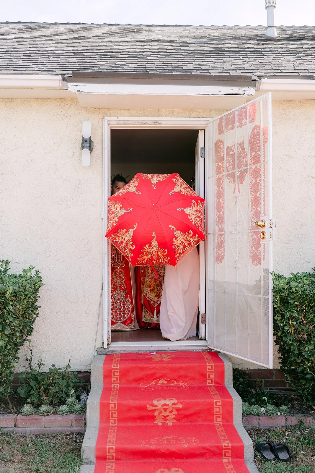 A red umbrella and red runner waiting at the family's front door.