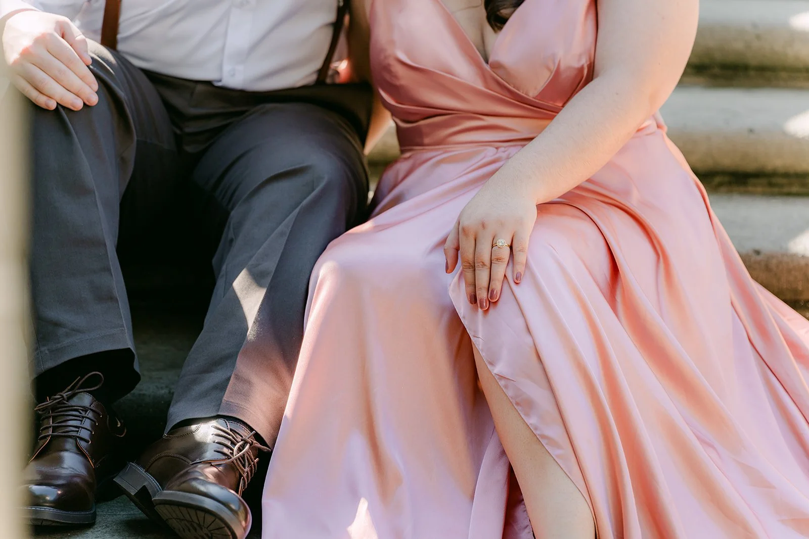 Saira and Matthew seated on the stone steps, hands together on her satin gown.