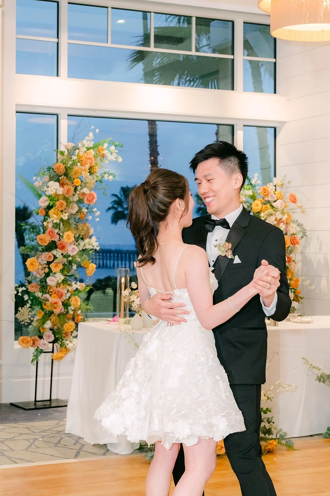 Angela and Eli starting their first dance, Angela in a short white reception dress