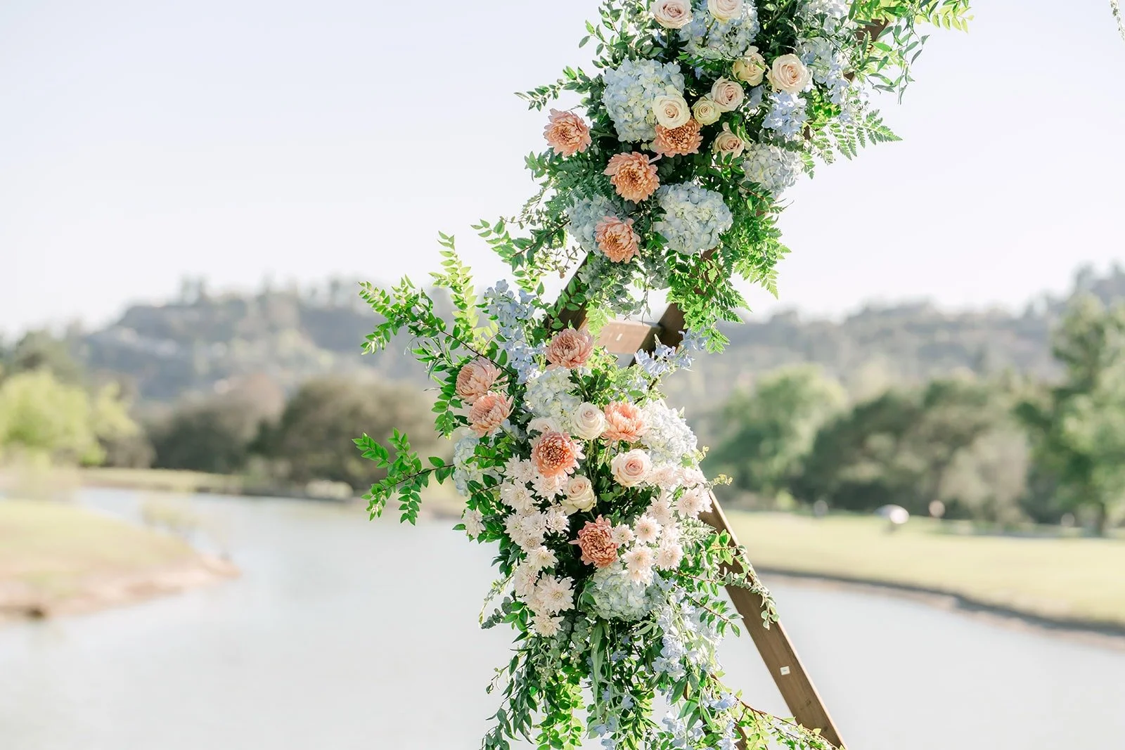 Florals on the ceremony arch with the water and hills beyond