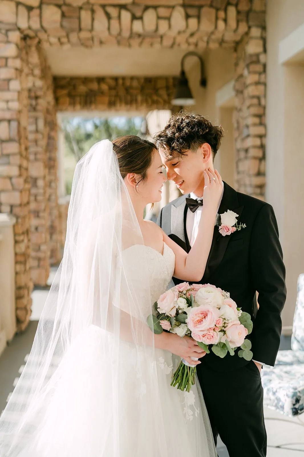 Couple sharing a tender moment under the stone archway