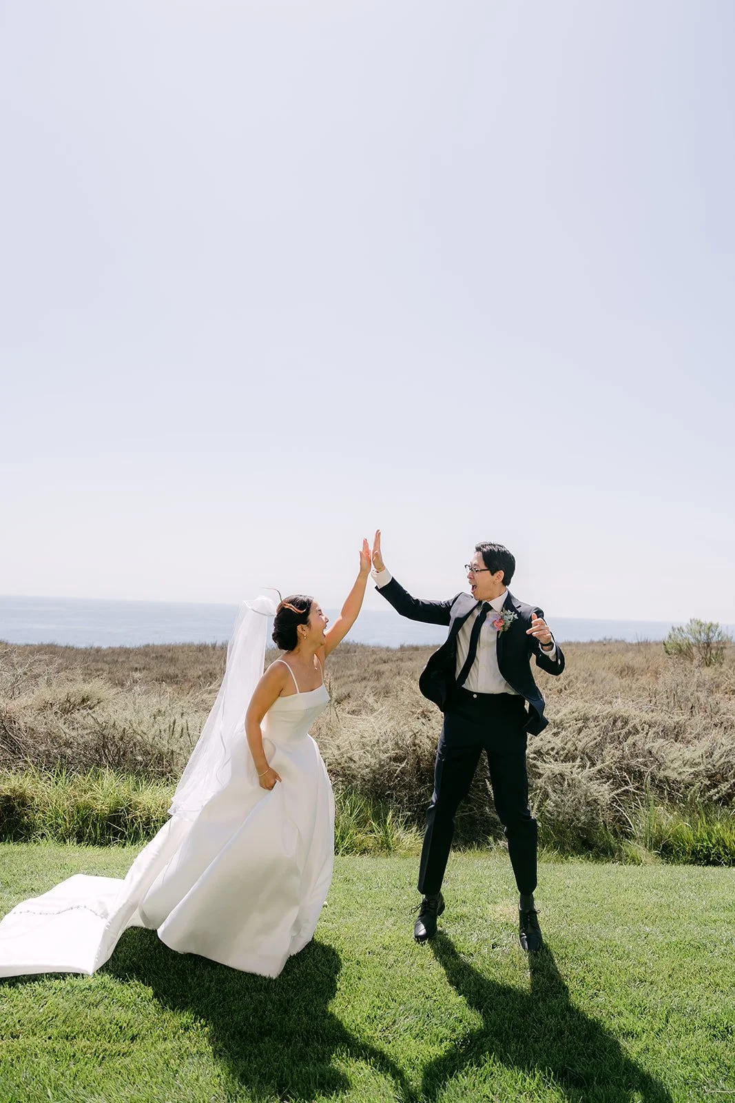 A celebratory high-five on the coastal lawn